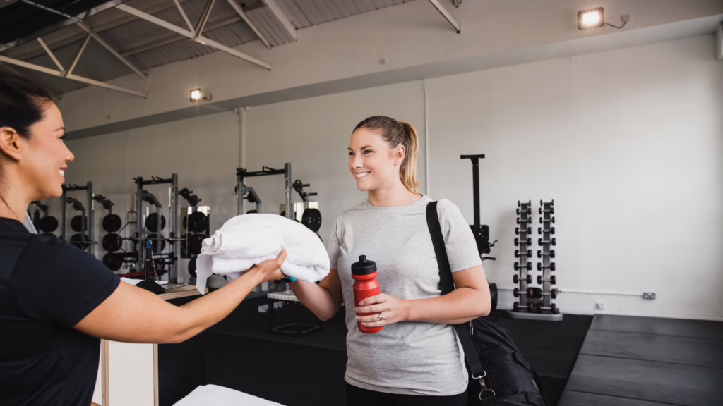 Femme qui prend une serviette dans une salle de sport