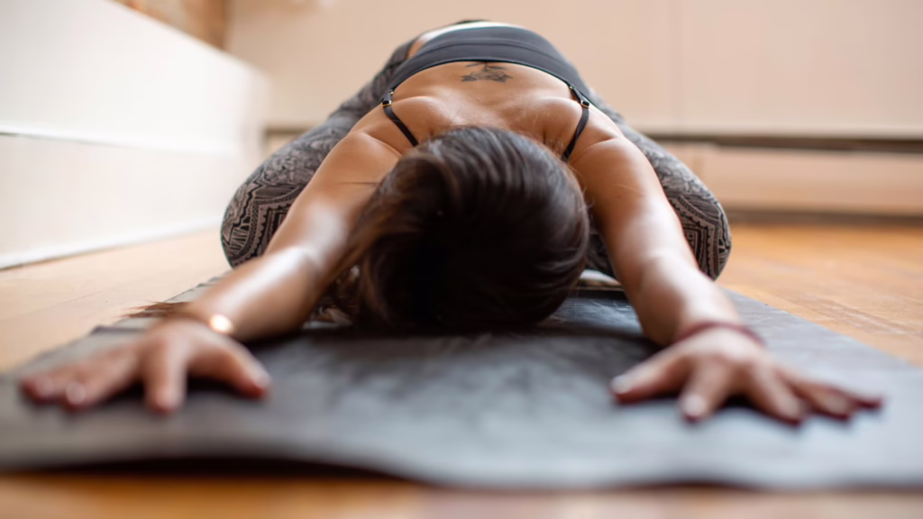Professeur de yoga qui montre la pratique sur son tapis