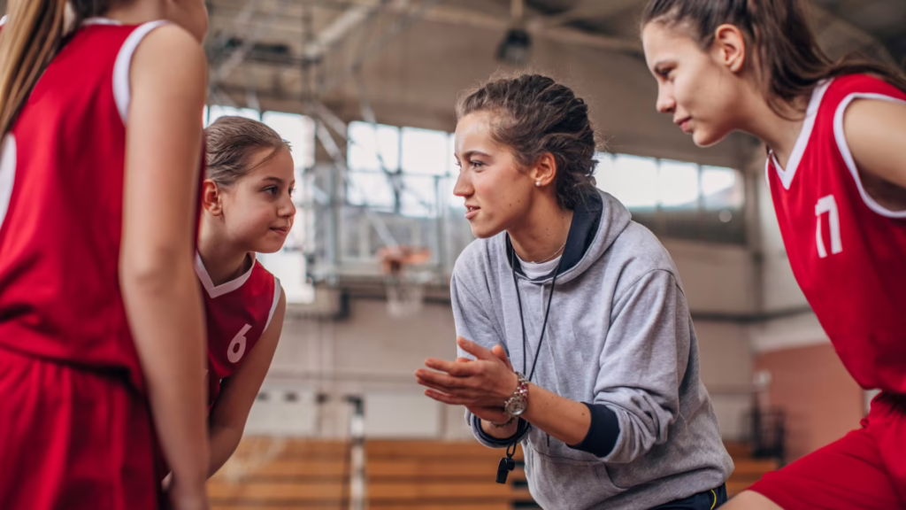 Coach qui entraîne son équipe de basket avec sa carte professionnelle de coach sportif.